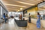 A round kitchen island with bar tables on one side and a long counter on the opposite wall.