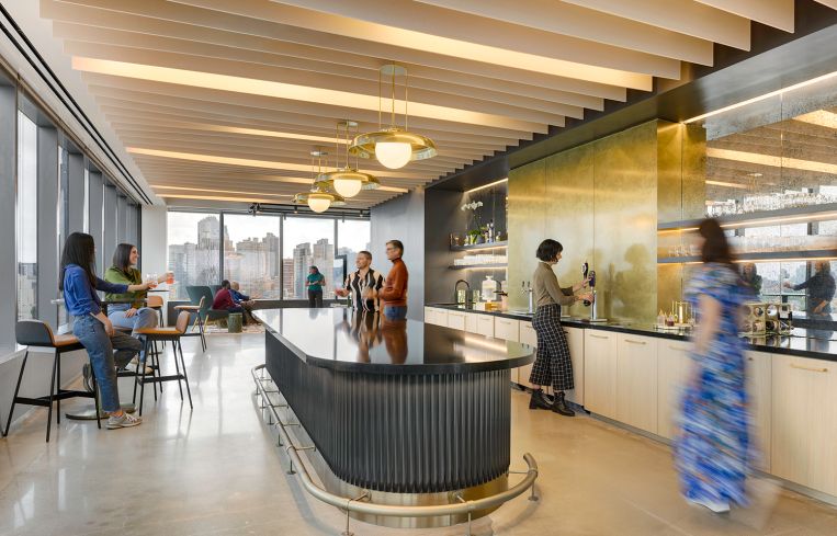 A round kitchen island with bar tables on one side and a long counter on the opposite wall.