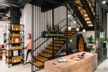 A staircase inside an office surrounded by desks, bookcases and indoor plants.