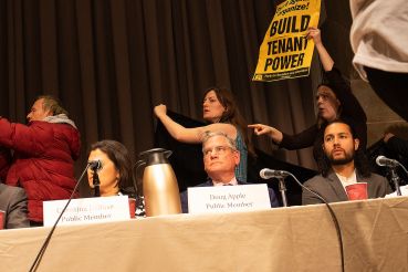 Public members Christina DeRose (from left) and Doug Apple, and tenant member Adán Soltren, watch as tenants and housing rights activists disrupt a Rent Guidelines Board meeting in 2023.