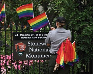 A National Park Service ranger places rainbow flags on the fence at the Stonewall National Monument in Greenwich Village.