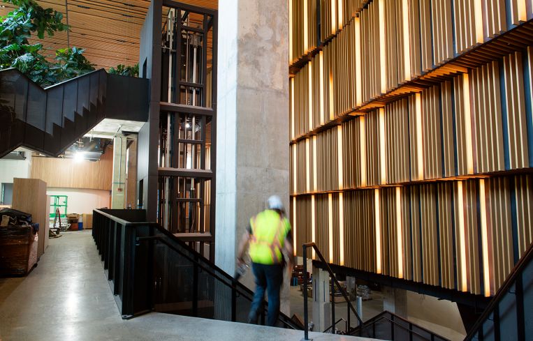 A construction working descending a wide staircase.