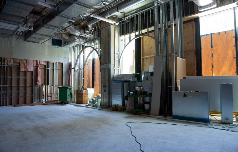 An unfinished fitness studio with arched windows.