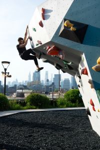 A climber on a rooftop climbing wall.