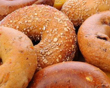 Closeup of assorted bagels, including sesame seed, egg bagel, mulit-grain, cinnamon raisin and plain.