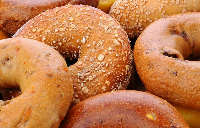 Closeup of assorted bagels, including sesame seed, egg bagel, mulit-grain, cinnamon raisin and plain.
