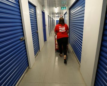 A woman walks through the hallways of a self-storage unit.