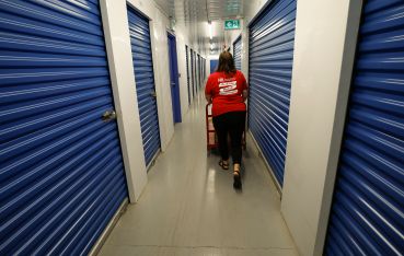 A woman walks through the hallways of a self-storage unit.