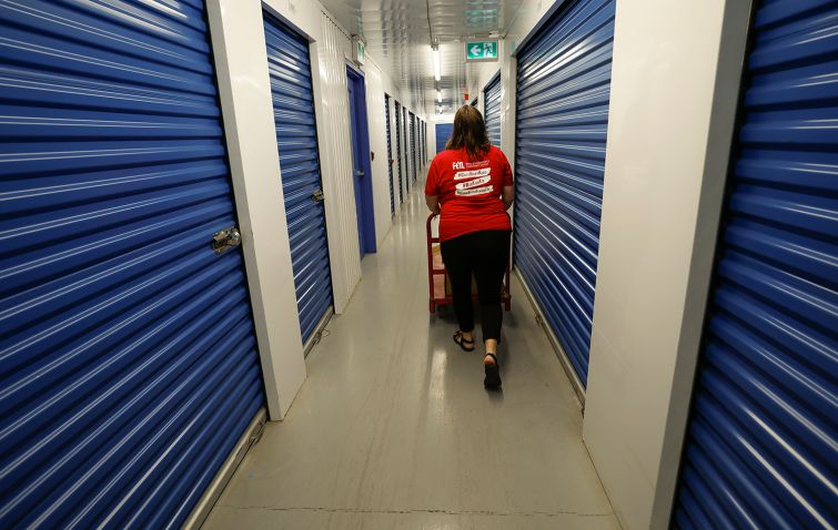 A woman walks through the hallways of a self-storage unit.