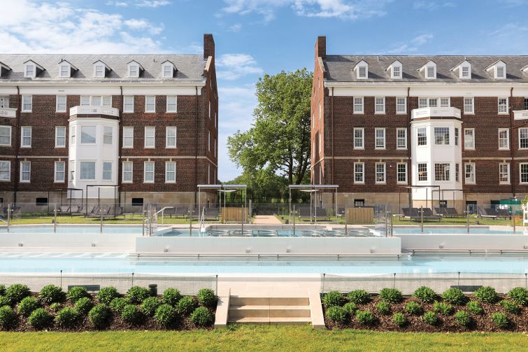 A view of two buildings and a pool that's apart of QC NY spa.