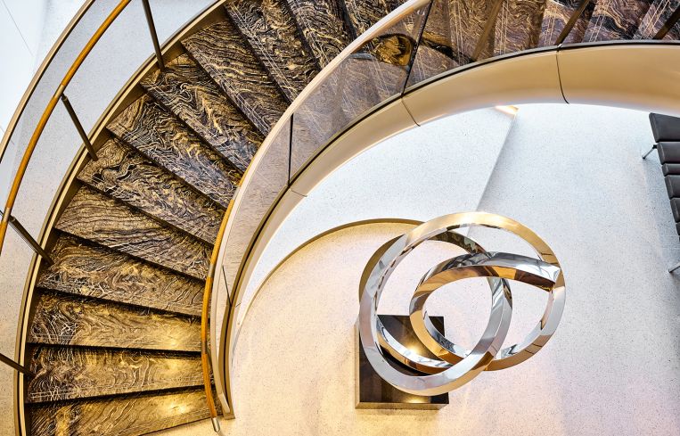 A spiral staircase leading to an abstract sculpture.