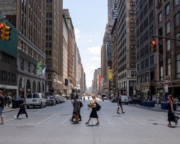 People walking on a crosswalk in New York City.