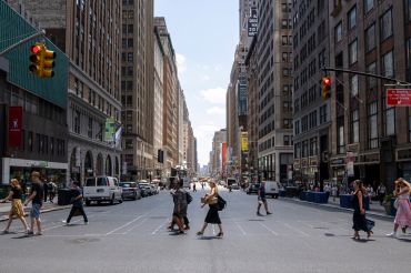 People walking on a crosswalk in New York City.