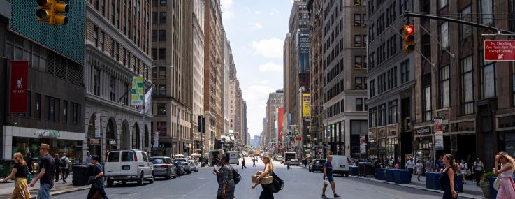 People walking on a crosswalk in New York City.