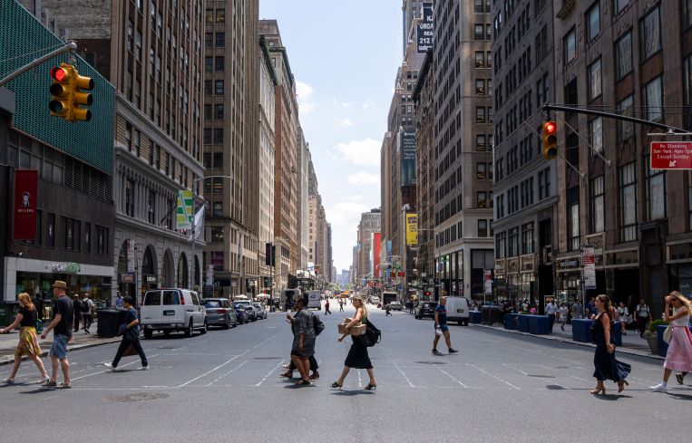 People walking on a crosswalk in New York City.