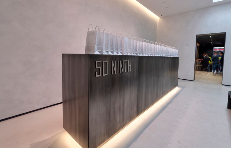 A dark wood reception desk with recessed lighting.