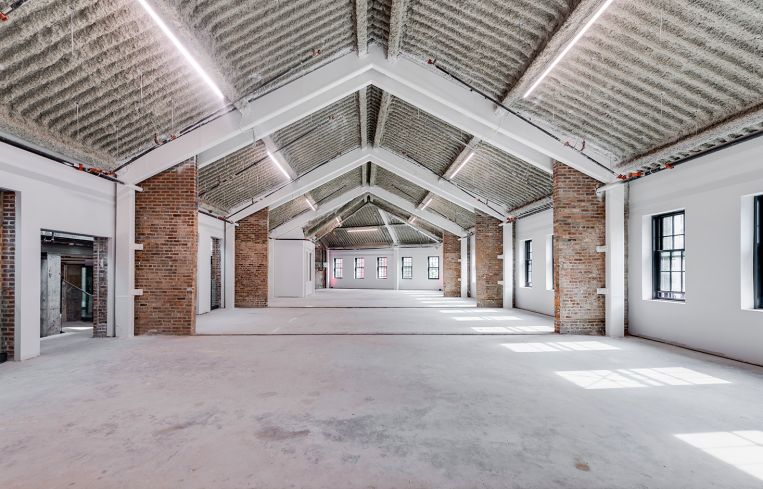 A long, empty attic space with white floors.