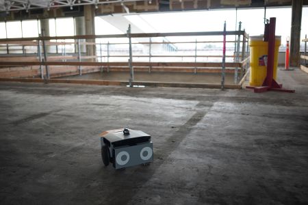 A squat, square robot in a warehouse.