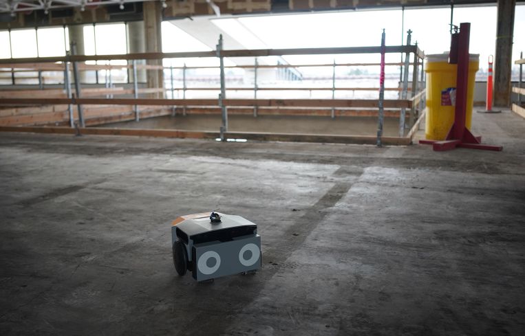 A squat, square robot in a warehouse.