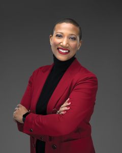 A woman smiling with her arms folded.