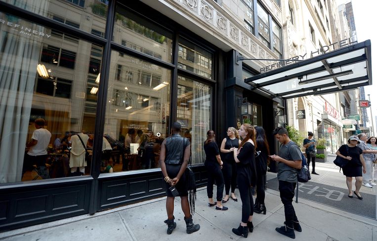 People wait outside the Refinery Hotel for an event.