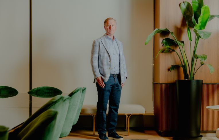 Wes Rogers stands in an office.