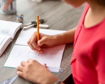 close up of student doing school work at a desk