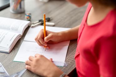 close up of student doing school work at a desk