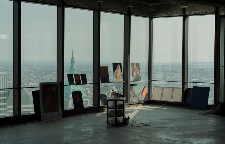 Paintings hang on the window sill of an office building.