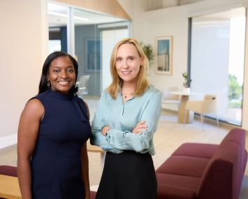 Two women standing in an office.