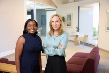 Two women standing in an office.