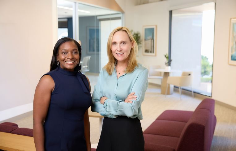 Two women standing in an office.