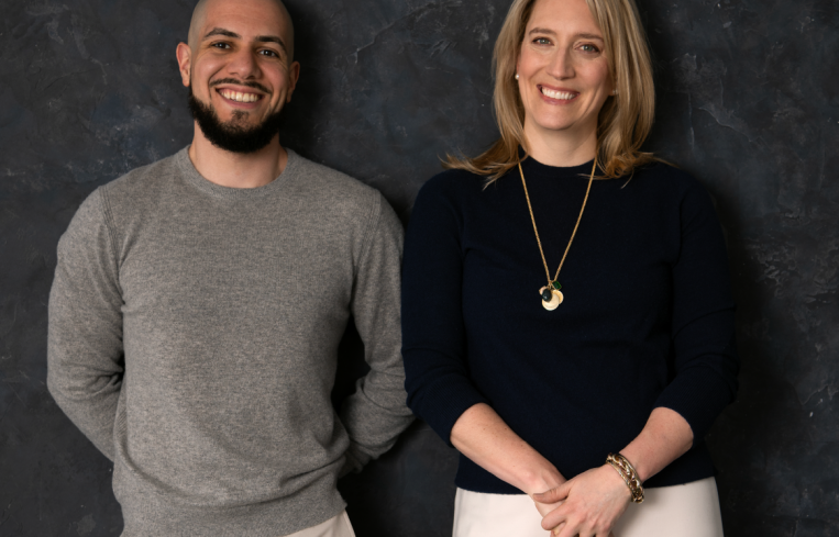 A man and a woman standing next to each other and smiling.