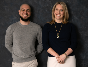 A man and a woman standing next to each other and smiling.