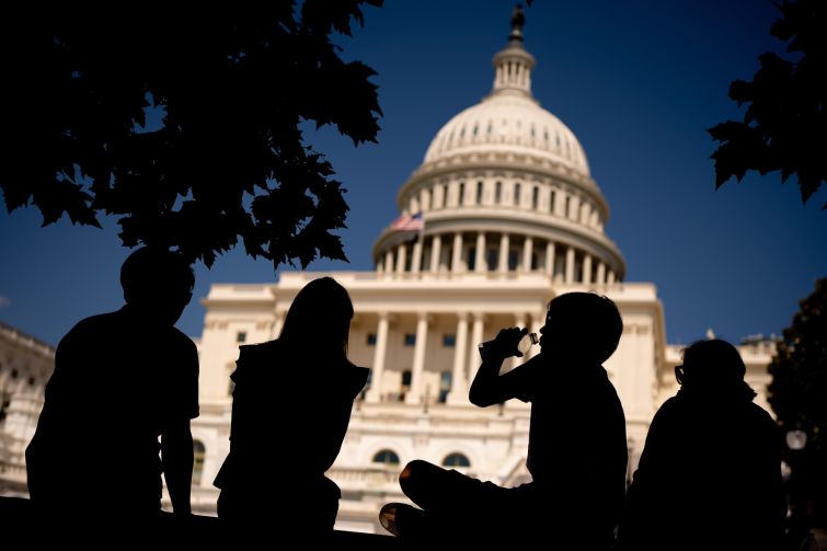 A young visitor to the U.S. Capitol Building takes a drink in the shade as much of the Northeast suffered a heat wave in summer 2024 in Washington, D.C.