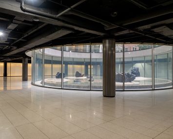 A glass circle surrounding a sculpture in the middle of an event space.
