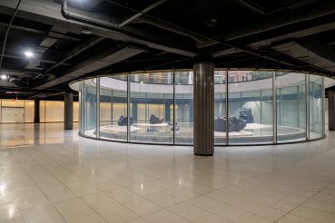 A glass circle surrounding a sculpture in the middle of an event space.