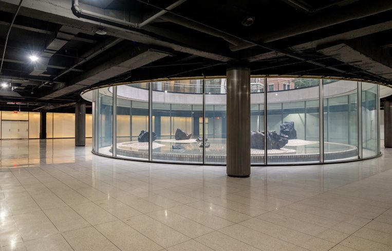 A glass circle surrounding a sculpture in the middle of an event space.