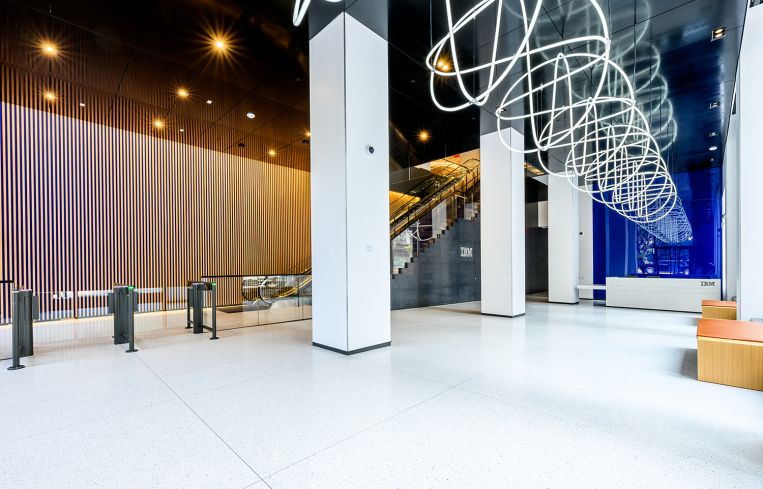 A private lobby with white tiles and a coiled white tube hanging overhead.