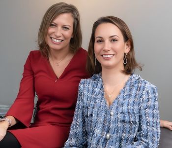 Two women, smiling.