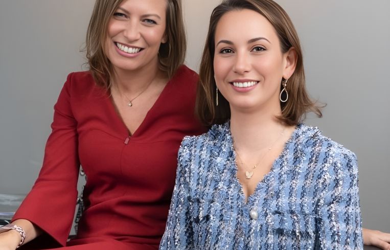 Two women, smiling.