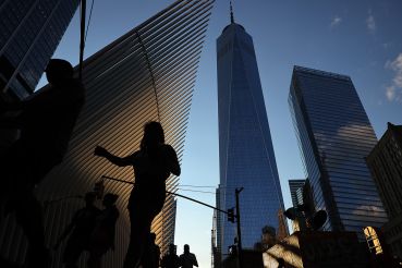 Pedestrians cross Church Street near One World Trade Center and the Oculus.