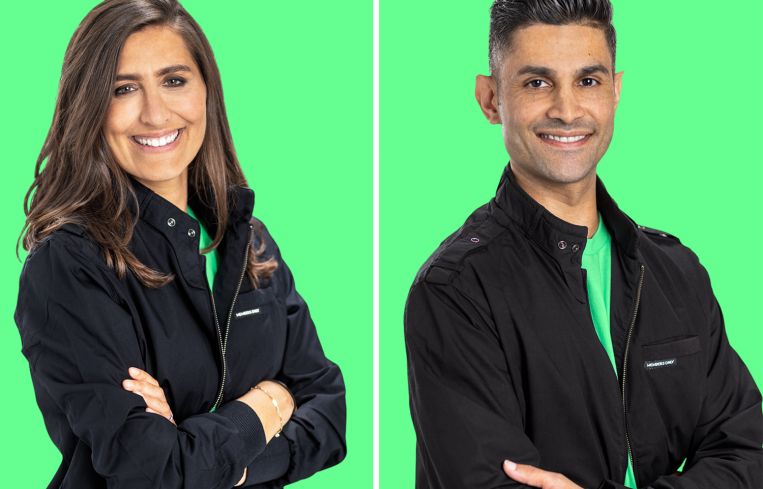 A woman and a man next to each other with their arms folded and smiling.