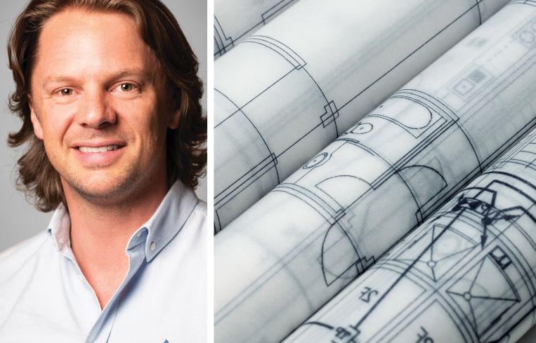 A man's face next to some rolled-up blueprints.
