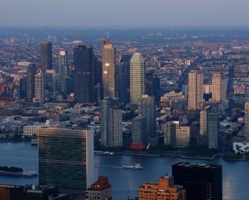 The sun sets on the United Nations and buildings in Long Island City.