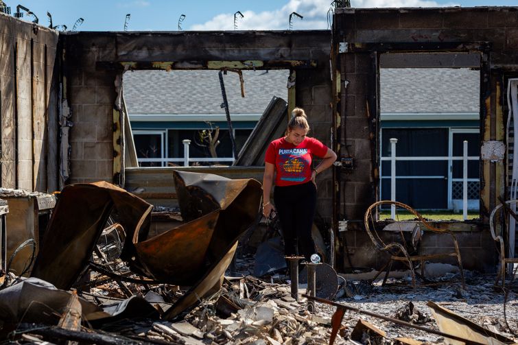 A woman looking at her burned out home after Hurricane Milton.