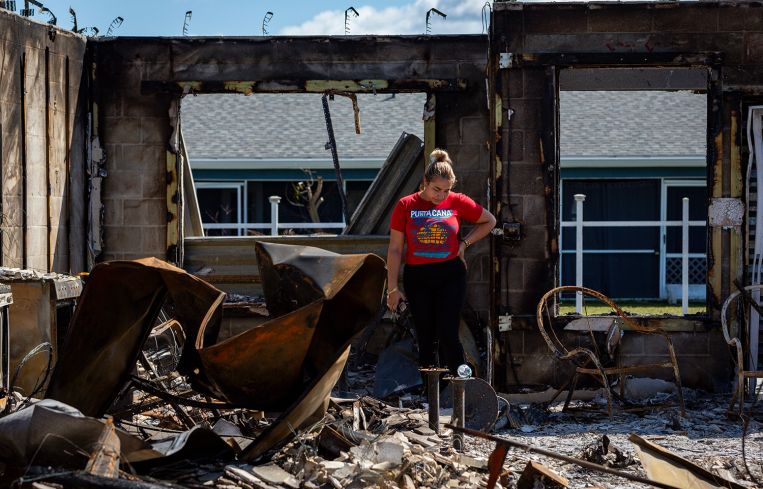 A woman looking at her burned out home after Hurricane Milton.
