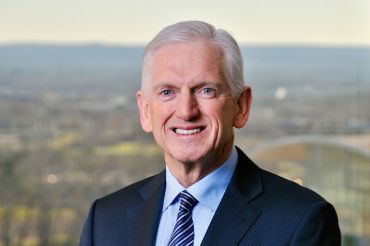 A man in a suit smiling.