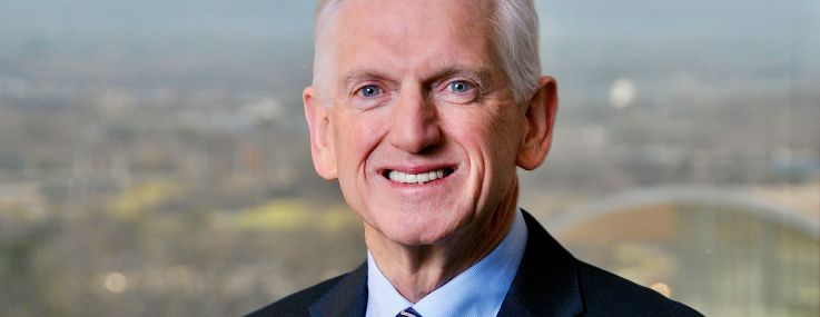 A man in a suit smiling.