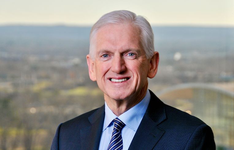 A man in a suit smiling.